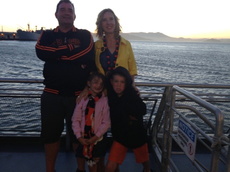 A family shot while being blown away by the wind at the back of the ferry.